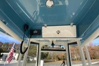 Interior view of 2026 Cobia 285 Center Console boat with blue ceiling and equipment.