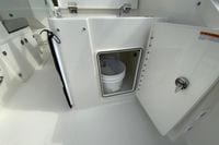 2026 Pursuit DC 266 Dual Console boat interior storage compartment with bucket.