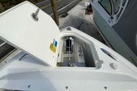 Open anchor compartment on 2026 Pursuit DC 266 Dual Console boat, docked near a road.