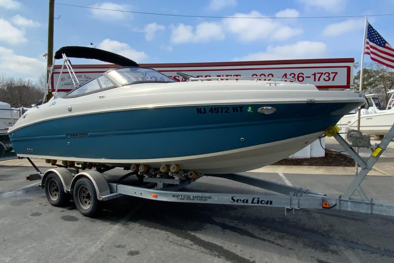 2023 Stingray 231 DC boat on trailer, displayed outdoors with American flag.