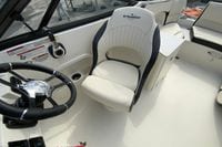 2023 Stingray 231 DC boat interior with steering wheel and captain's chair.