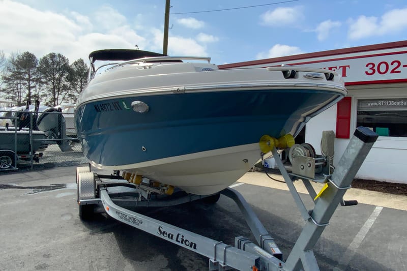 2023 Stingray 231 DC boat on trailer, parked outside dealership.