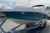 2023 Stingray 231 DC boat on trailer, blue and white design, parked outdoors.