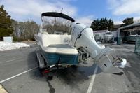 2023 Stingray 231 DC boat with Suzuki outboard motor on trailer in dealership lot.