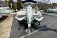 2023 Stingray 231 DC boat, rear view, parked outdoors with American flag nearby.