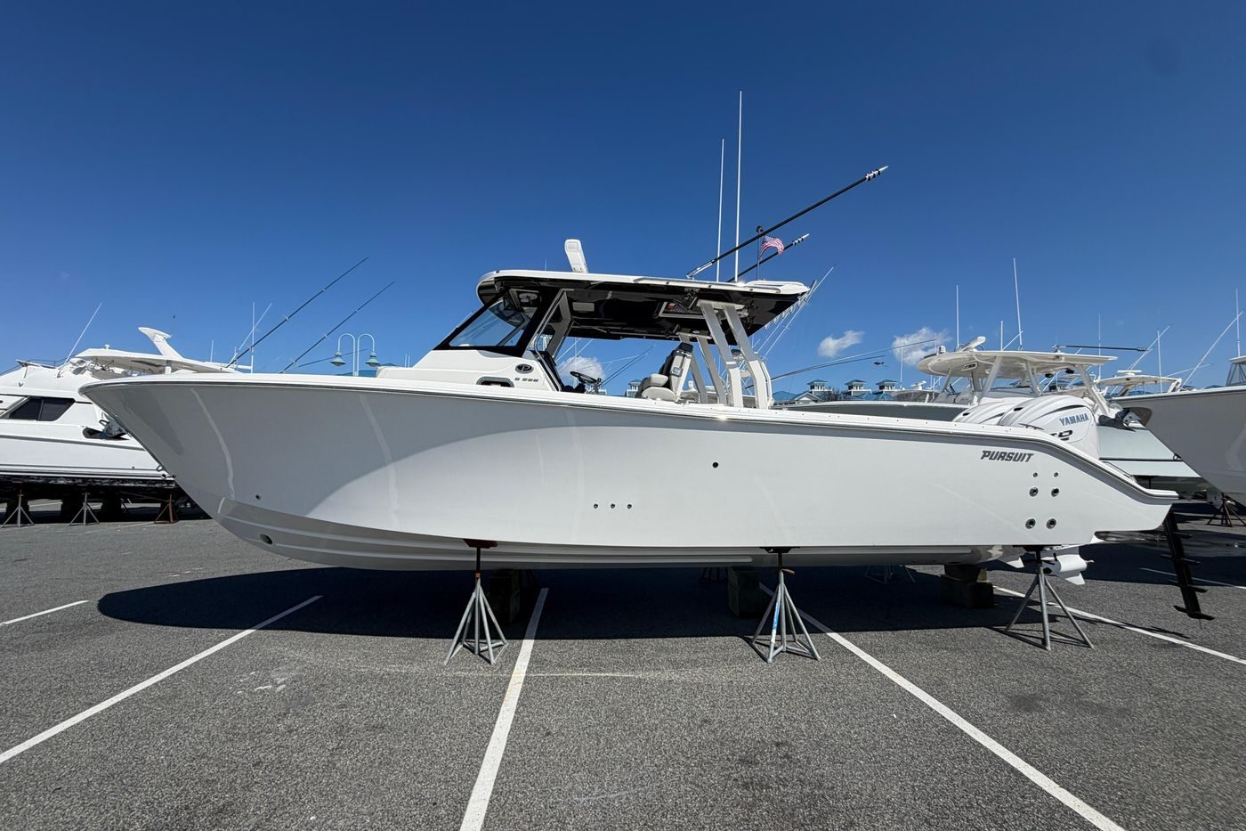 2026 Pursuit S 358 Sport boat displayed on stands in a marina.