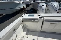 2026 Pursuit S 358 Sport boat with twin outboard engines, docked at a marina.