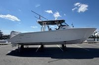 2026 Pursuit S 358 Sport boat displayed on stands under a clear blue sky.