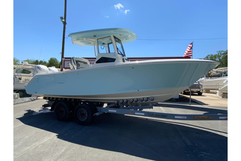 2026 Cobia 245 Center Console boat on trailer, displayed outdoors under clear blue sky.