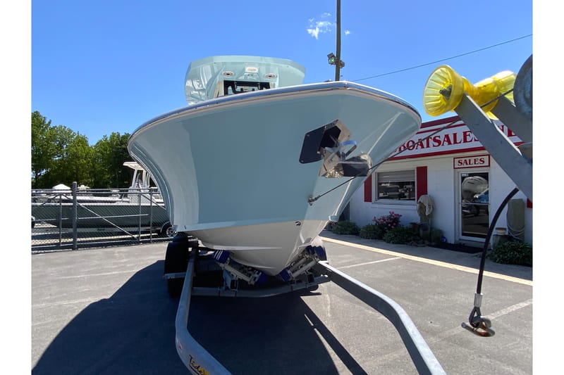 2026 Cobia 245 Center Console boat on trailer at dealership under clear blue sky.