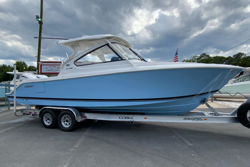 2026 Pursuit DC 286 Dual Console boat on trailer, under cloudy sky.