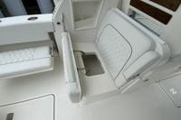 2026 Pursuit DC 286 Dual Console boat interior with white cushioned seating and storage compartment.