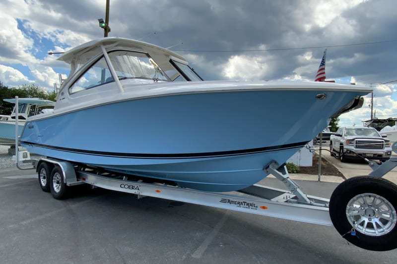 2026 Pursuit DC 286 Dual Console boat on trailer under cloudy sky.