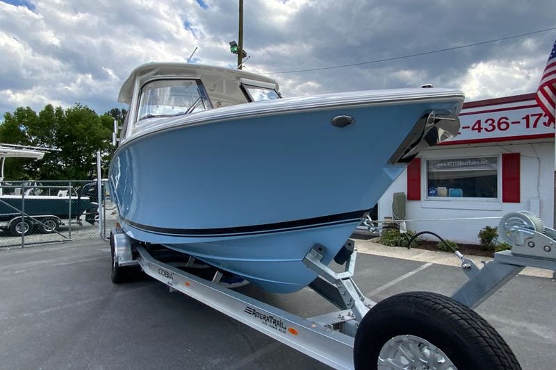 2026 Pursuit DC 286 Dual Console boat on trailer, displayed outdoors under cloudy sky.