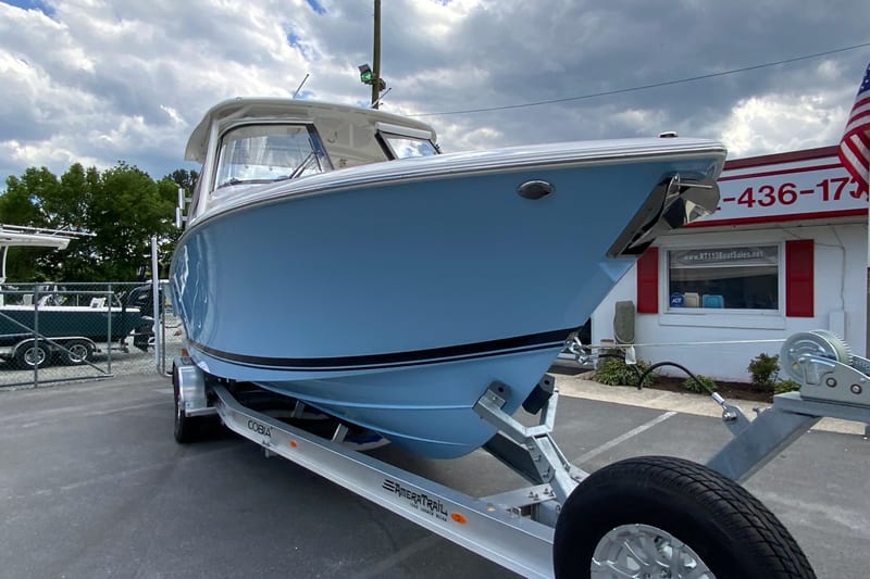 2026 Pursuit DC 286 Dual Console boat on trailer, displayed outdoors under cloudy sky.