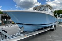 2026 Pursuit DC 286 Dual Console boat on trailer under cloudy sky.