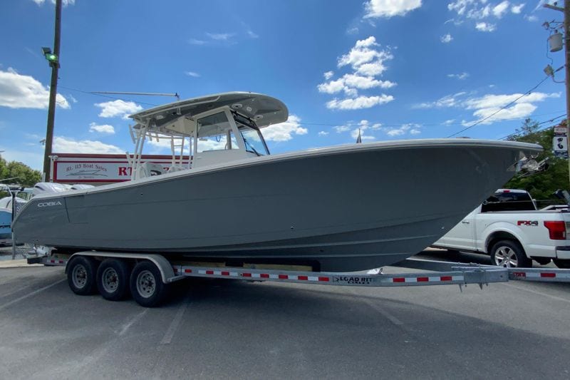 2027 Cobia 320 Center Console boat on trailer under blue sky.