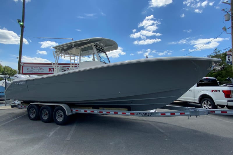 2027 Cobia 320 Center Console boat on trailer under blue sky.