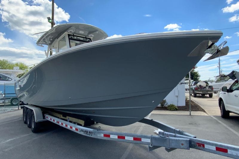 2027 Cobia 320 Center Console boat on trailer under blue sky.