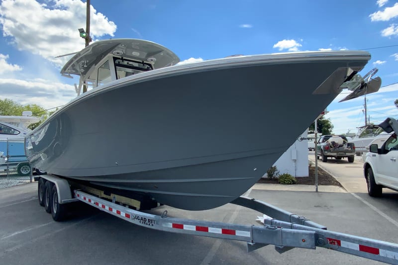 2027 Cobia 320 Center Console boat on trailer under blue sky.