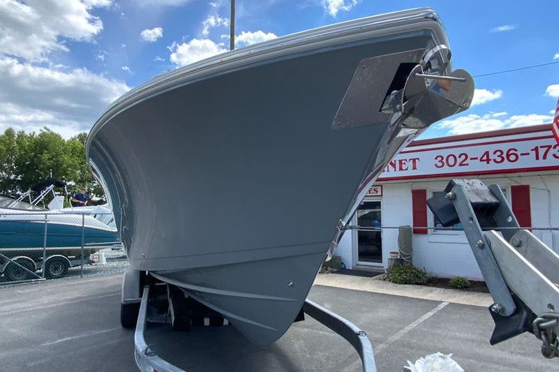 2027 Cobia 320 Center Console boat on trailer, parked outdoors under a blue sky.