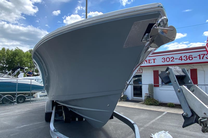 2027 Cobia 320 Center Console boat on trailer, parked outdoors under a blue sky.