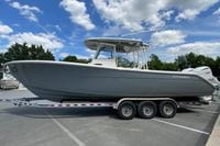2027 Cobia 320 Center Console boat on trailer under blue sky.