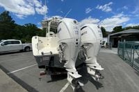 2027 Cobia 320 Center Console with twin Yamaha 350 engines in a parking lot.