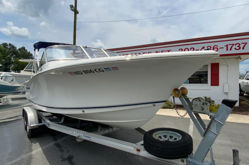 2014 Sea Hunt Escape 211 LE boat on trailer, parked outside dealership.