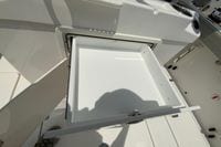 Open storage compartment on 2027 Pursuit S 268 Sport boat, showcasing interior space.