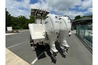 2027 Pursuit S 268 Sport boat with dual Yamaha 200 engines in a parking lot.