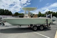 2023 Pathfinder 2400 TRS boat on trailer at dealership under blue sky.