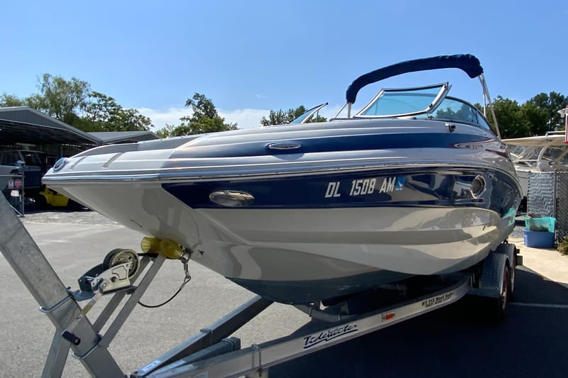 2019 Crownline Eclipse E235 XS boat on trailer, blue and white design, sunny day.