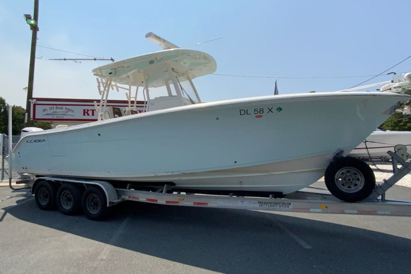 2018 Cobia 301 Center Console boat on a trailer at a dealership.