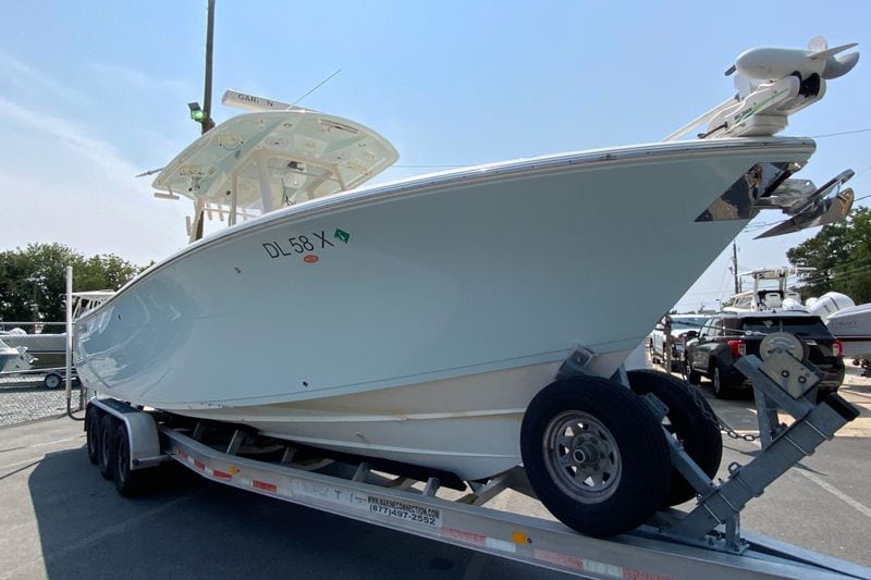2018 Cobia 301 Center Console boat on trailer, parked outdoors.
