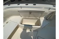 2018 Cobia 301 Center Console boat with open storage compartment on deck.