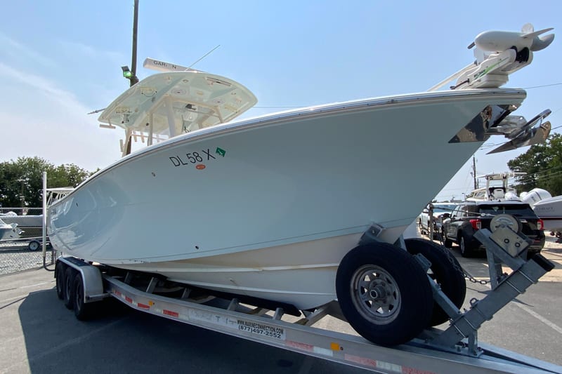 2018 Cobia 301 Center Console boat on trailer, parked outdoors.