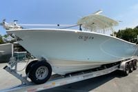 2018 Cobia 301 Center Console boat on trailer, side view.