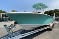2023 Sportsman Open 232 Center Console boat on trailer, teal hull, parked outdoors.