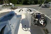 2010 Hurricane SunDeck Sport 200 OB boat interior with steering console and seating area.