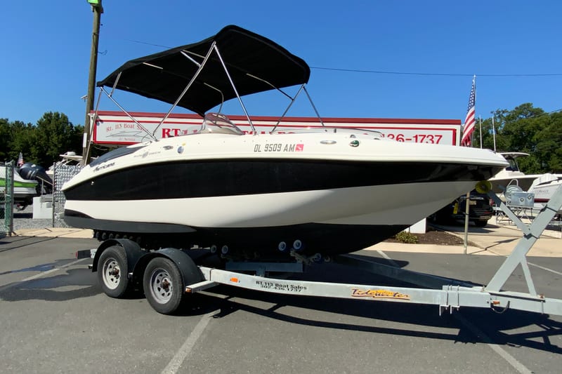 2010 Hurricane SunDeck Sport 200 OB boat on trailer at dealership.