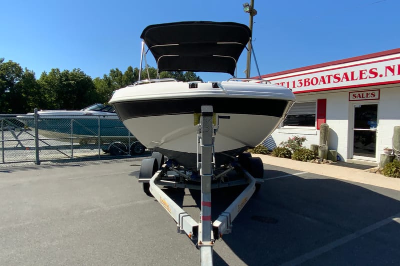 2010 Hurricane SunDeck Sport 200 OB boat on trailer at dealership.