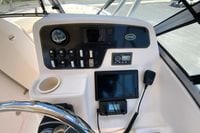 Grady-White Freedom 255 boat dashboard with navigation controls, steering wheel, and communication devices.