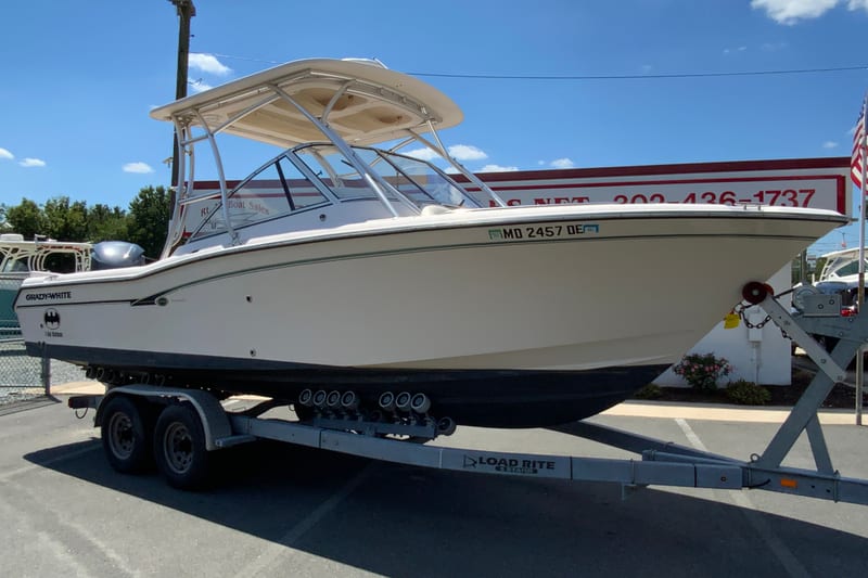 2011 Grady-White Freedom 255 boat on trailer at dealership, sunny day.