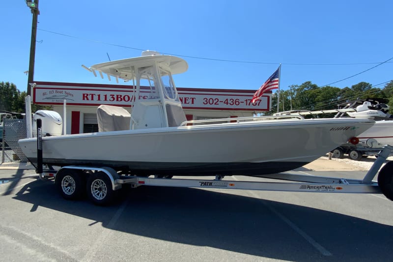 2025 Pathfinder 2600 TRS boat on trailer at dealership, American flag in background.