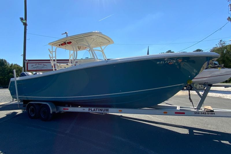 2014 Sailfish 290 CC boat on trailer in outdoor setting.