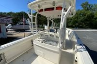 2014 Sailfish 290 CC boat with T-top and console, parked outdoors.