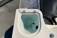 Livewell on 2014 Sailfish 290 CC boat, open lid, showing interior and water.