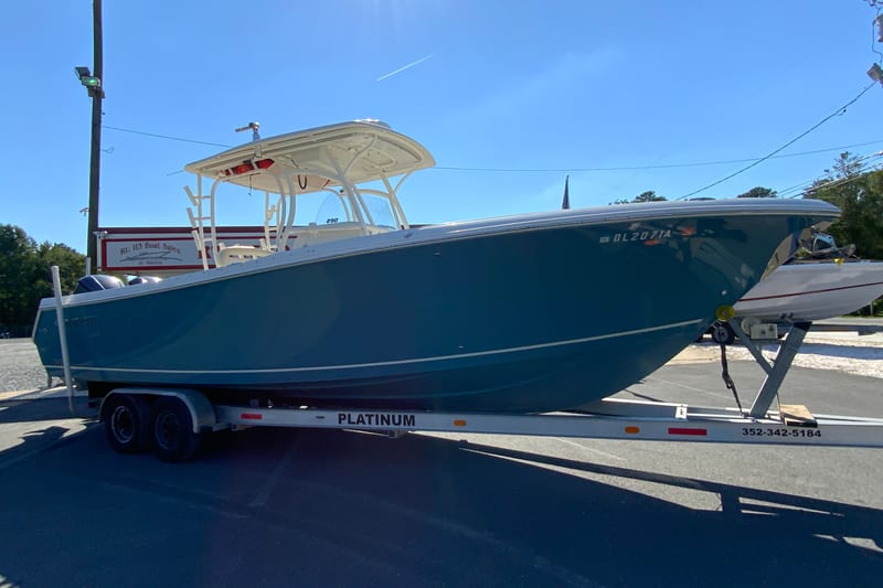 2014 Sailfish 290 CC boat on trailer in outdoor setting.