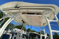 2014 Sailfish 290 CC boat's helm station with T-top and electronics, under clear blue sky.